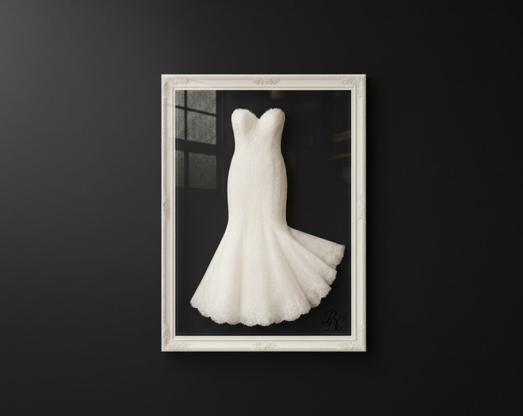 "Elegant strapless mermaid wedding dress framed in white ornate shadow box against a matte black wall, showcasing professional bridal gown preservation and display by Bridal Dry Cleaning Experts in Sydney.
