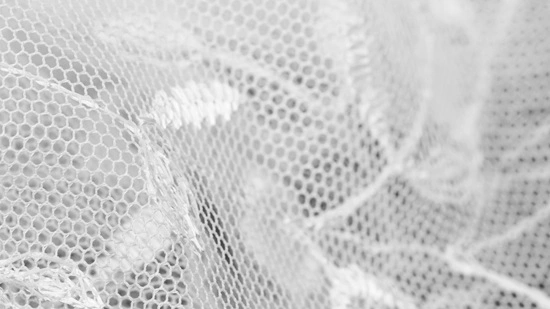 Close-up of bridal lace fabric showing intricate floral threadwork pattern