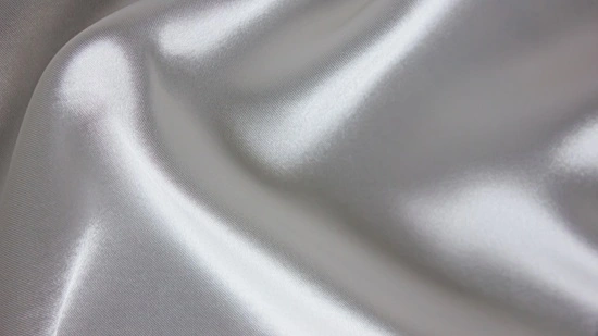 Close-up of bridal satin fabric showing reflective surface and fluid drape