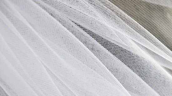 Close-up of bridal tulle fabric showing fine mesh net weave pattern