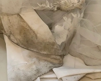 Mud and dirt stain on white wedding dress hem before dry brushing treatment