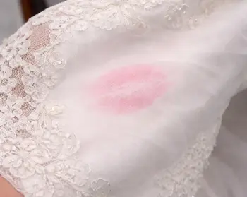 Lipstick stain on bridal gown fabric before wax-dissolving pre-treatment