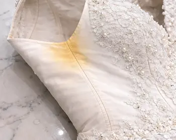 Perspiration yellowing on white bridal gown underarm area before enzyme pre-soak
